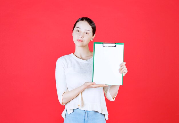 Portrait of beautiful woman holding clipboard