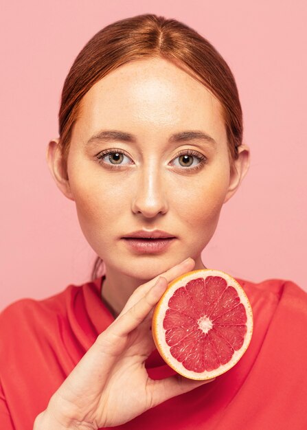 Портрет красивой женщины, держащей фрукт