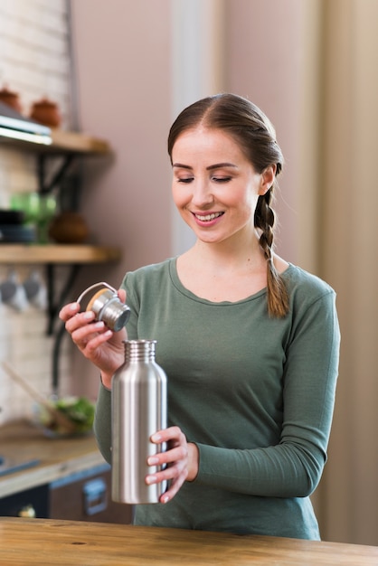 Ritratto di bella donna che tiene thermos