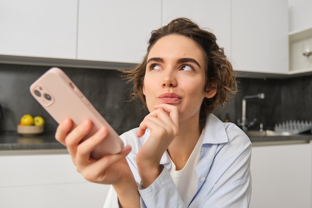 Portrait of beautiful woman at home holding smartphone online shopping from mobile phone app