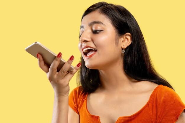 Portrait of beautiful woman isolated on yellow studio background