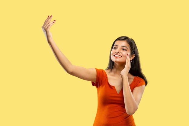 Portrait of beautiful woman isolated on yellow studio background