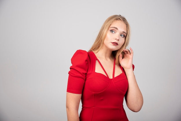 Portrait of beautiful woman looking at her side on gray background.