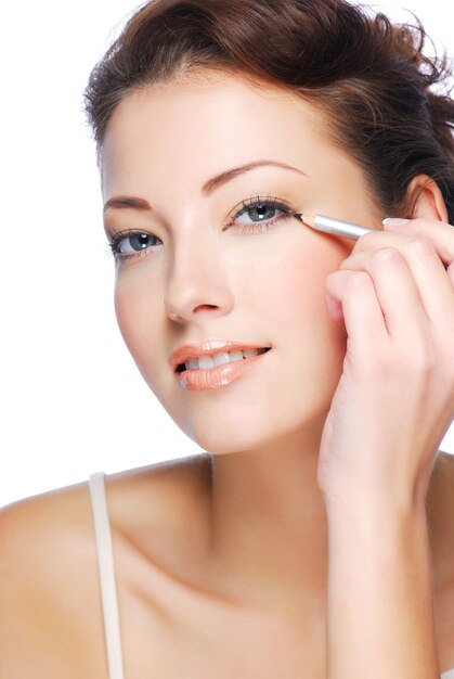 Portrait of beautiful woman making make-up  using black  cosmetic pencil