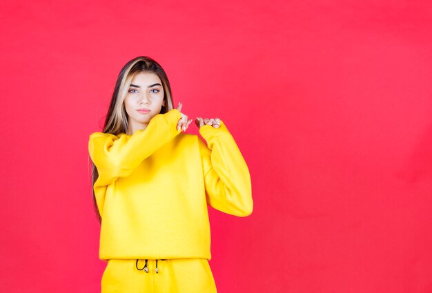 Portrait of beautiful woman model standing and pointing aside with finger