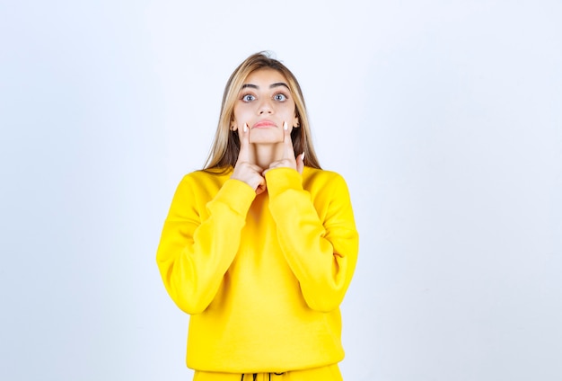 Portrait of beautiful woman model standing and pointing at her cheeks