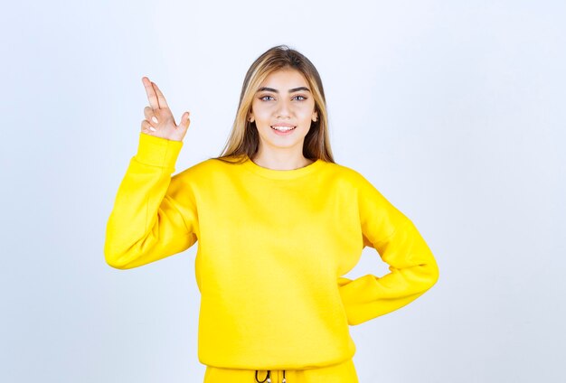 Portrait of beautiful woman model standing and pointing up