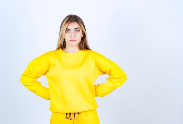 Portrait of beautiful woman model standing and posing in yellow t-shirt