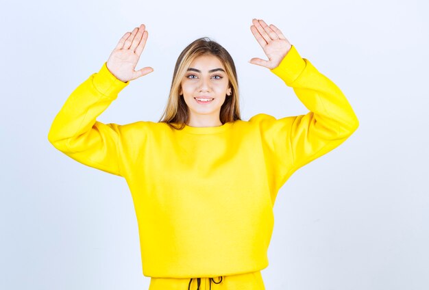 Portrait of beautiful woman model standing and raising hands