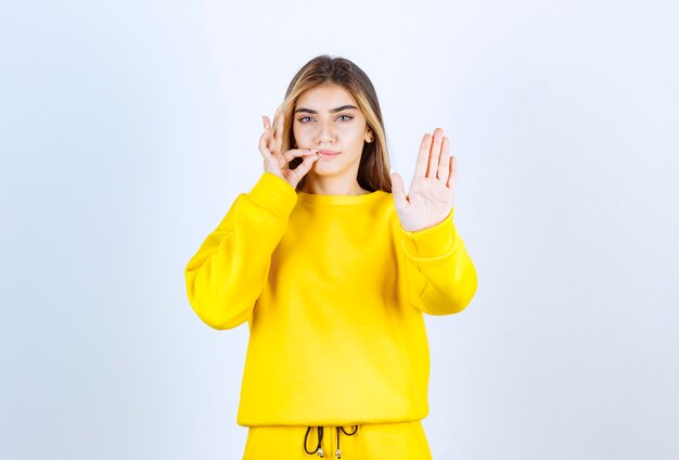 Portrait of beautiful woman model standing and showing number five with hand