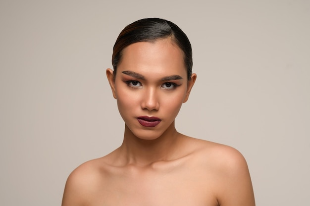 portrait of beautiful woman model with fresh daily make-up and perfect smiles with beautiful face on gray wall in studio