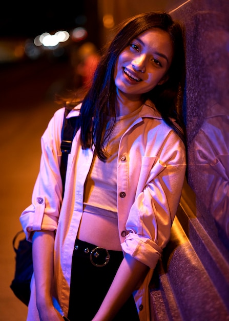 Portrait of beautiful woman at night in the city lights