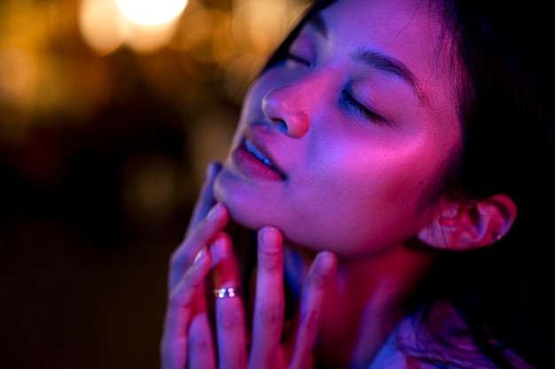 Portrait of beautiful woman at night in the city lights