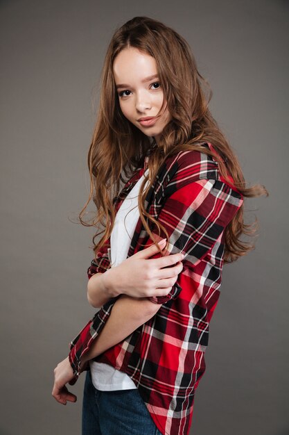 Portrait of beautiful woman in plaid shirt standing and posing