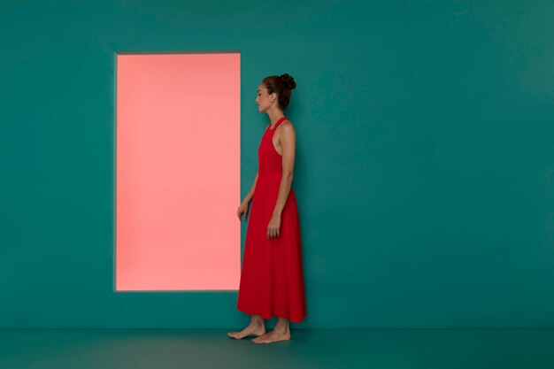 Portrait of beautiful woman posing in a flowy red dress with copy space