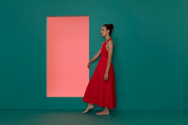 Free photo portrait of beautiful woman posing in a flowy red dress with copy space