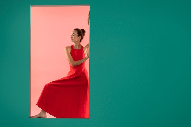 Portrait of beautiful woman in flowy red dress with copy space