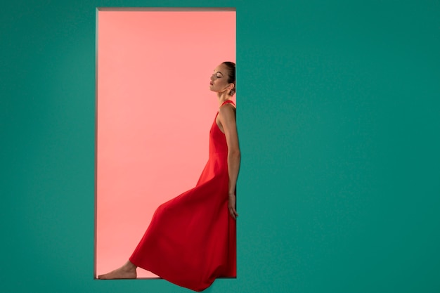 Portrait of beautiful woman posing in a flowy red dress with copy space