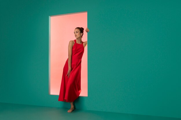 Portrait of beautiful woman posing in a flowy red dress with copy space