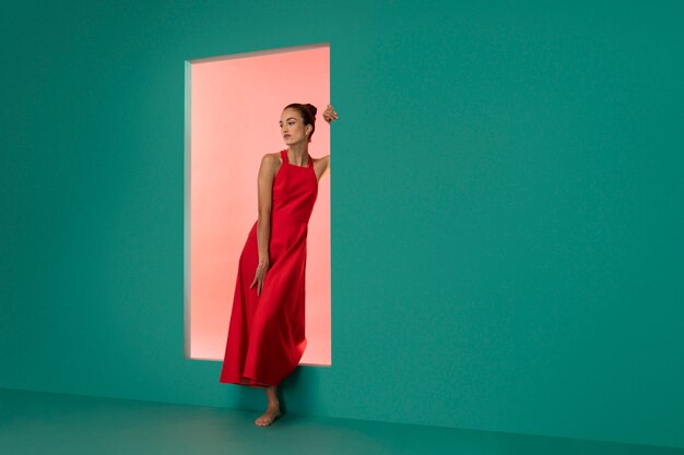 Портрет красивой женщины, позирующей в струящемся красном платье с копией пространства