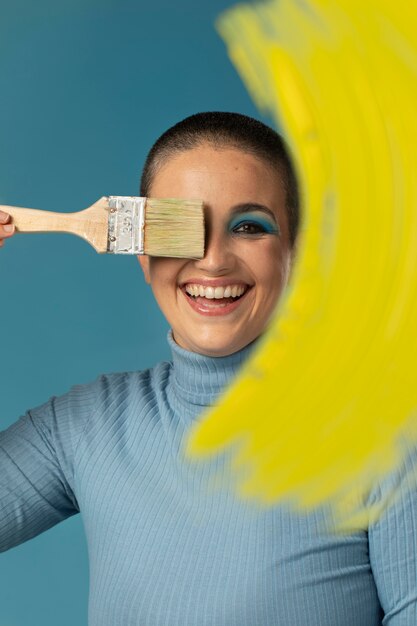 Free photo portrait of beautiful woman posing in a turtleneck with yellow paint brush stroke
