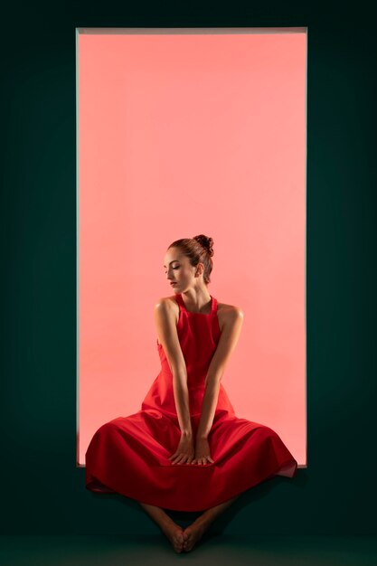 화려한 빨간 드레스와 함께 포즈를 취하는 아름 다운 여자의 초상화