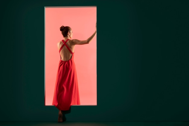 Foto gratuita ritratto di bella donna in posa con un vestito rosso fluido