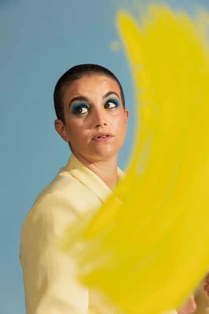 Portrait of beautiful woman posing with a yellow jacket and brush stroke