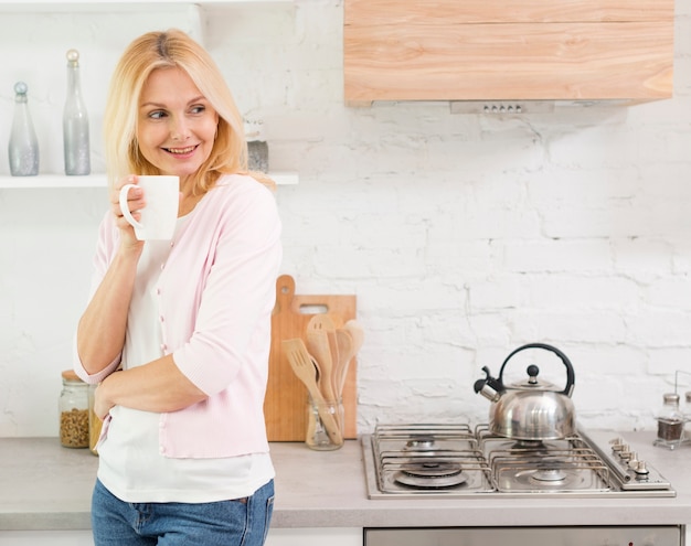 Portrait of beautiful woman serving coffee at home