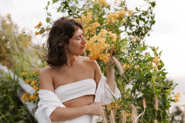 Free photo portrait of beautiful woman smells flowers