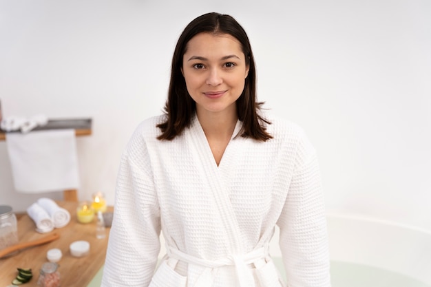 Free photo portrait of a beautiful woman standing by the bathtub before taking a bath