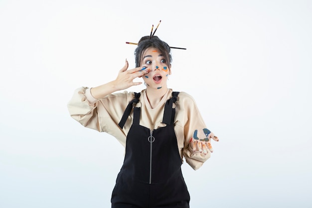 Free photo portrait of a beautiful woman standing and painting her face .