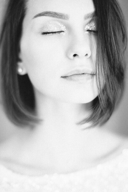 Портрет красивой женщины думая с глазами закрыл в белой верхней части. черное и белое