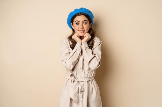 portrait of beautiful woman in trendy outfit touching her face and looking dreamy yearning smth stan...