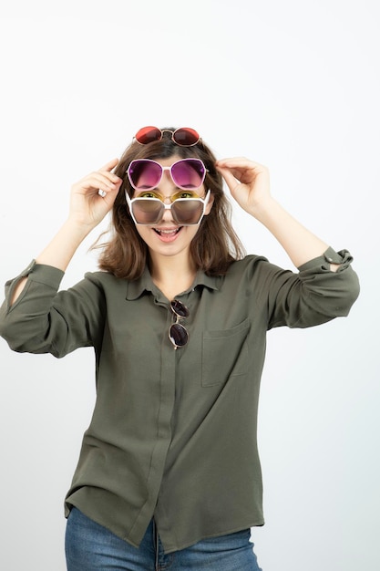 Free photo portrait of beautiful woman wearing many sun glasses over white. high quality photo