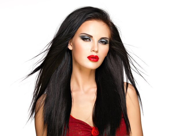 Portrait of  the beautiful woman with  black straight hairs and red lips, evening makeup. Pretty model posing at studio