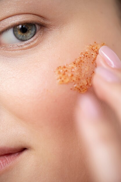 Portrait of beautiful woman with clear skin using face scrub