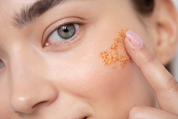 Portrait of beautiful woman with clear skin using face scrub