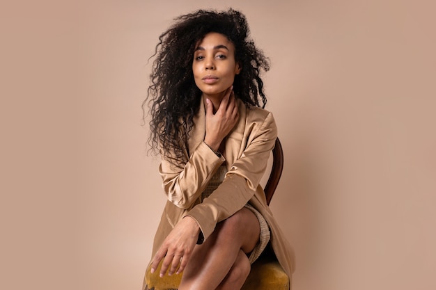 Portrait of a beautiful woman with perfect wavy hair in a golden shiny jacket