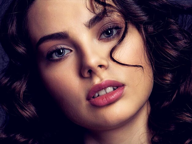 Portrait of a  beautiful woman with a smoky eye makeup. Sexy and gorgeous brunette woman with  curly hair. Portrait of an attractive female posing . Fashion model