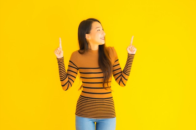 Portrait beautiful young asian adult woman smile with many action on yellow wall