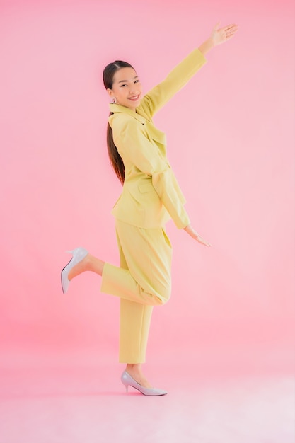 Portrait beautiful young asian business woman smile in action on pink color