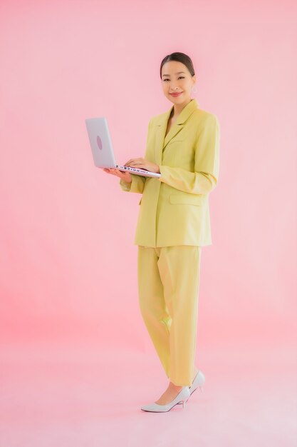 Portrait beautiful young asian business woman use computer laptop on color