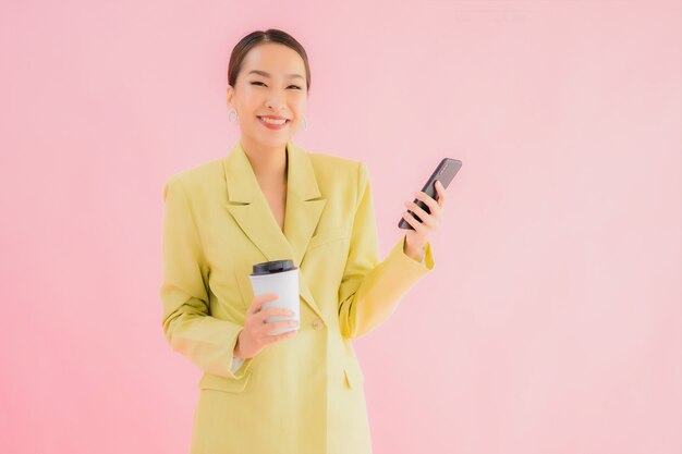 Portrait beautiful young asian business woman use smart mobile phone with coffee cup on color