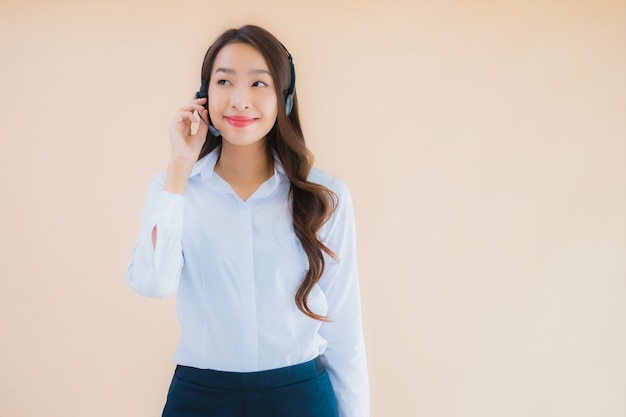 コールセンターのヘッドフォンで美しい若いアジアビジネス女性の肖像画