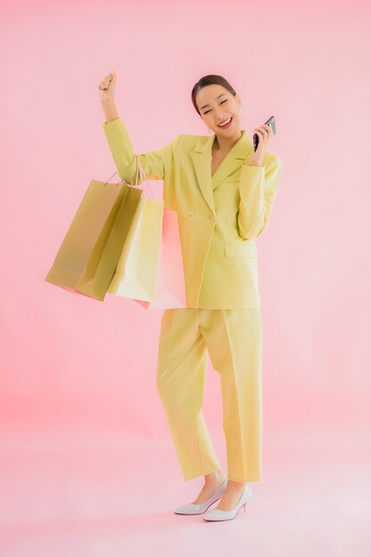 Portrait beautiful young asian business woman with shopping bag on color isolated