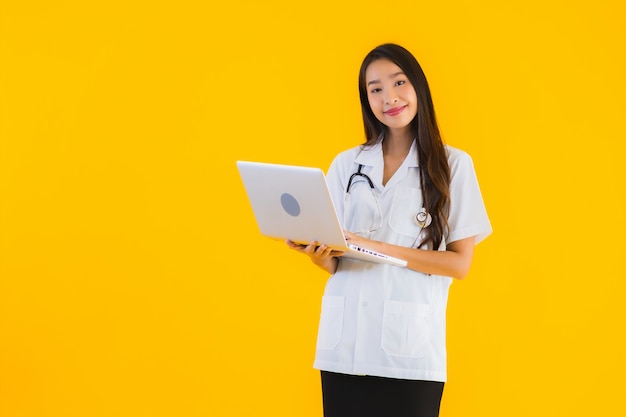 Portrait of beautiful young asian doctor woman uses laptop