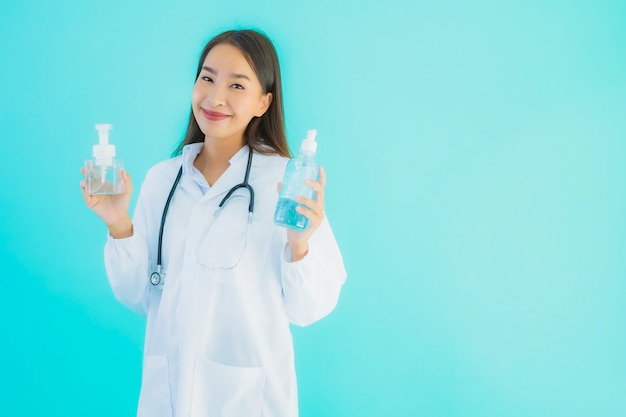 Free photo portrait beautiful young asian doctor woman with gel alcohol for clean hand