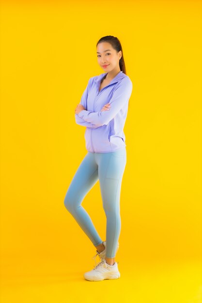 Portrait beautiful young asian sport woman ready for exercise on yellow