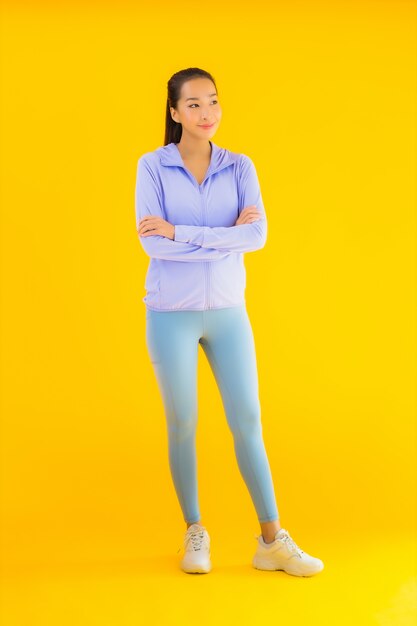 Portrait beautiful young asian sport woman ready for exercise on yellow